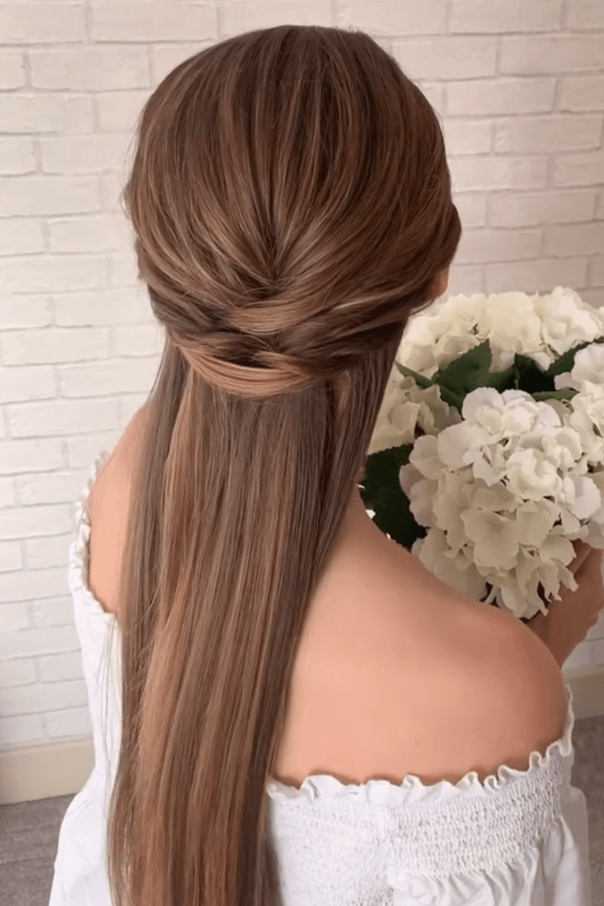 Minimalist half-up twisted hairstyle with smooth, straight, sleek lengths.