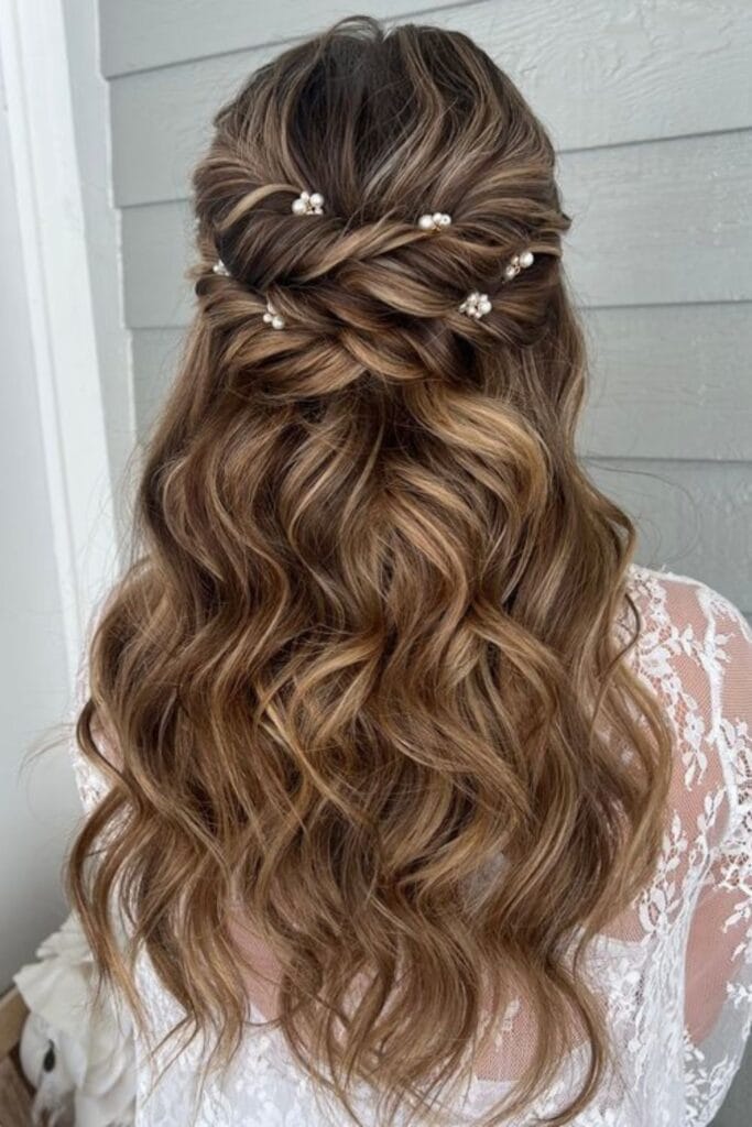 Blonde hairstyle featuring a soft braided crown wrapped around the head with long, voluminous loose waves cascading down the back.