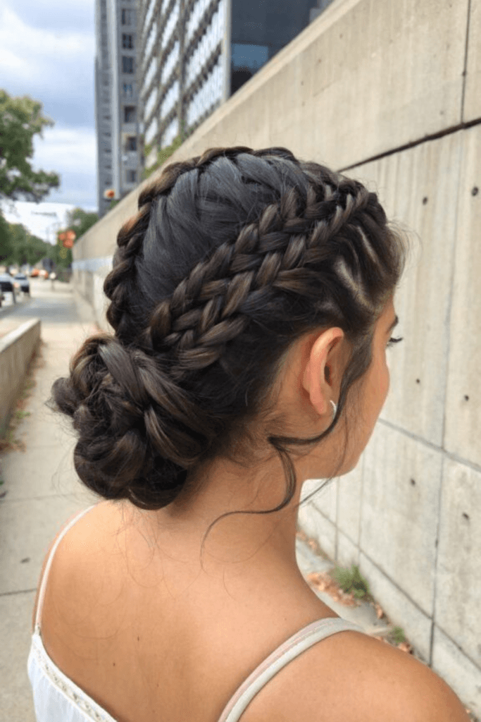 Intricate braided low updo with multiple braids woven into a textured bun at the nape.