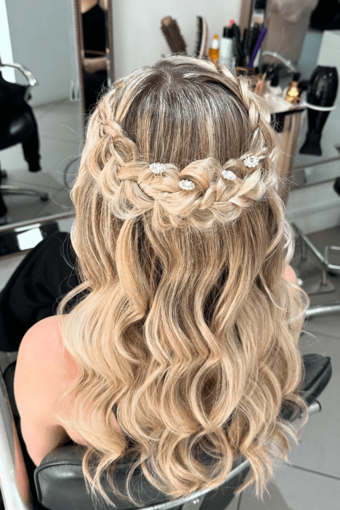Half-up hairstyle with loose soft waves and delicate pearl hair accessories woven through the crown.