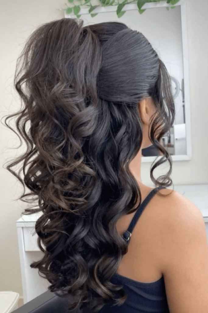 Sleek high ponytail with glossy, defined soft glam waves cascading down the back.