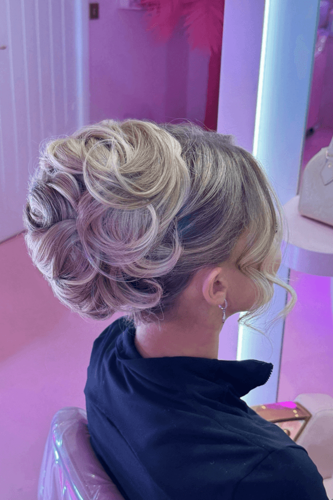 Voluminous curly updo with natural textured curls pinned into a soft romantic shape.