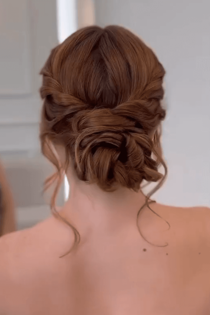 Soft textured low bun at the nape of the neck with loose face-framing strands.