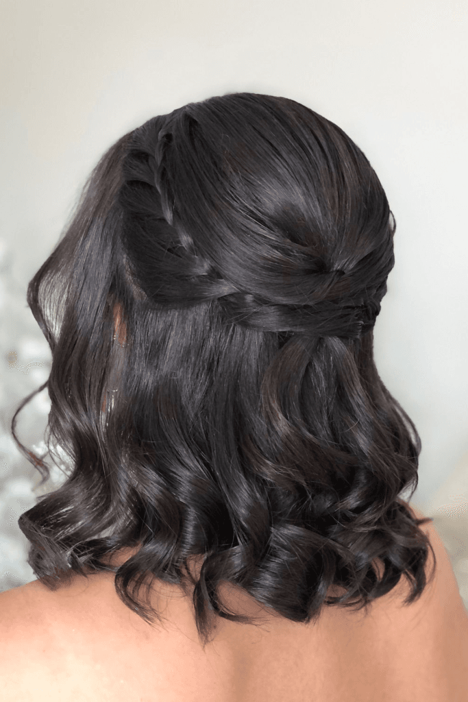 Twisted half-up hairstyle with voluminous, bouncy curls falling down the back.