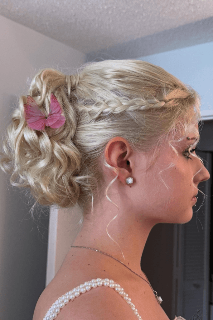 Romantic braided updo with soft face-framing tendrils.