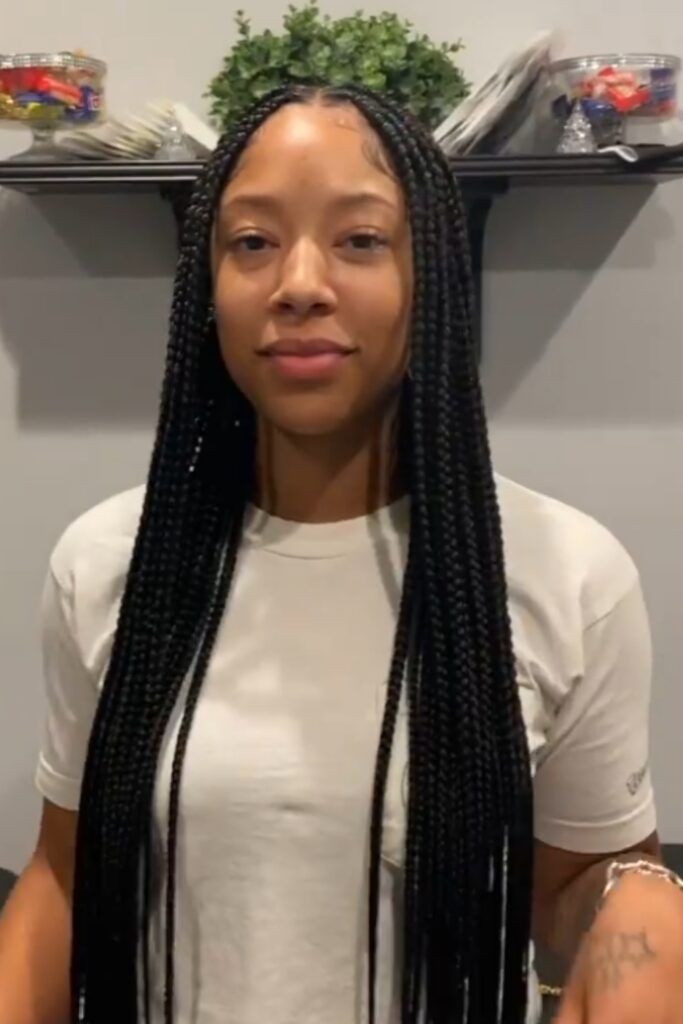 a lovely woman sporting knotless braids, one of the most popular back to school hairstyles for Black women