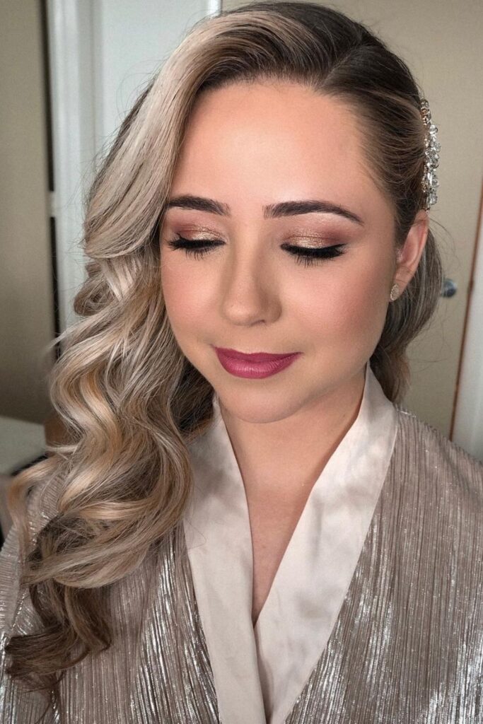 Blonde curls swept to one side and pinned with a crystal hair comb