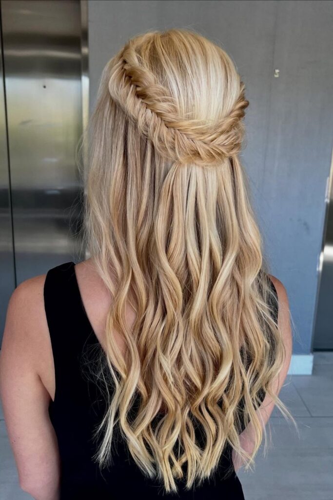 Fishtail braid pinned in a halo over long blonde waves