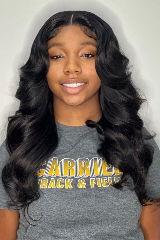 Center-parted body waves on long black hair, a homecoming hairstyle for Black hair