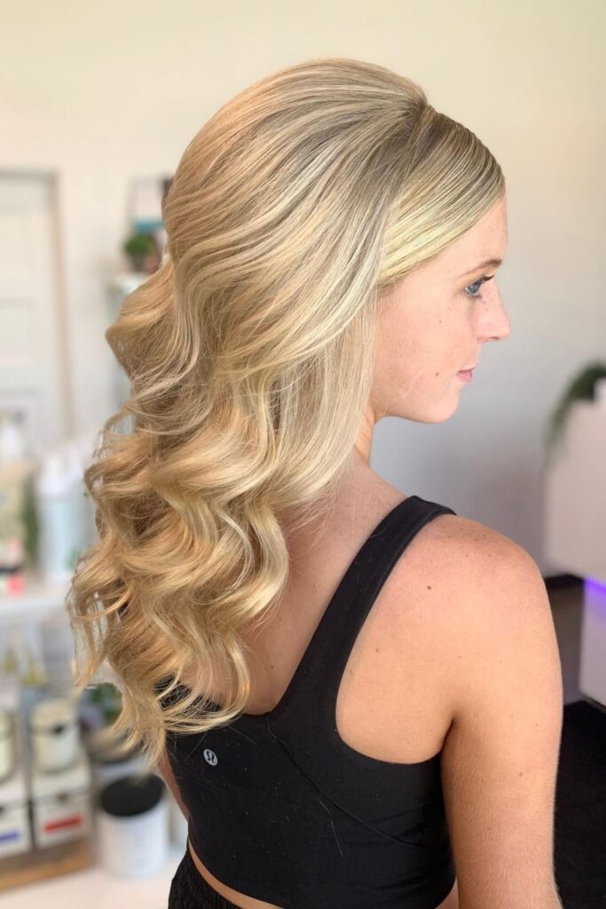 Blonde hair smoothed flat at the front with volume at the crown and curls at the back