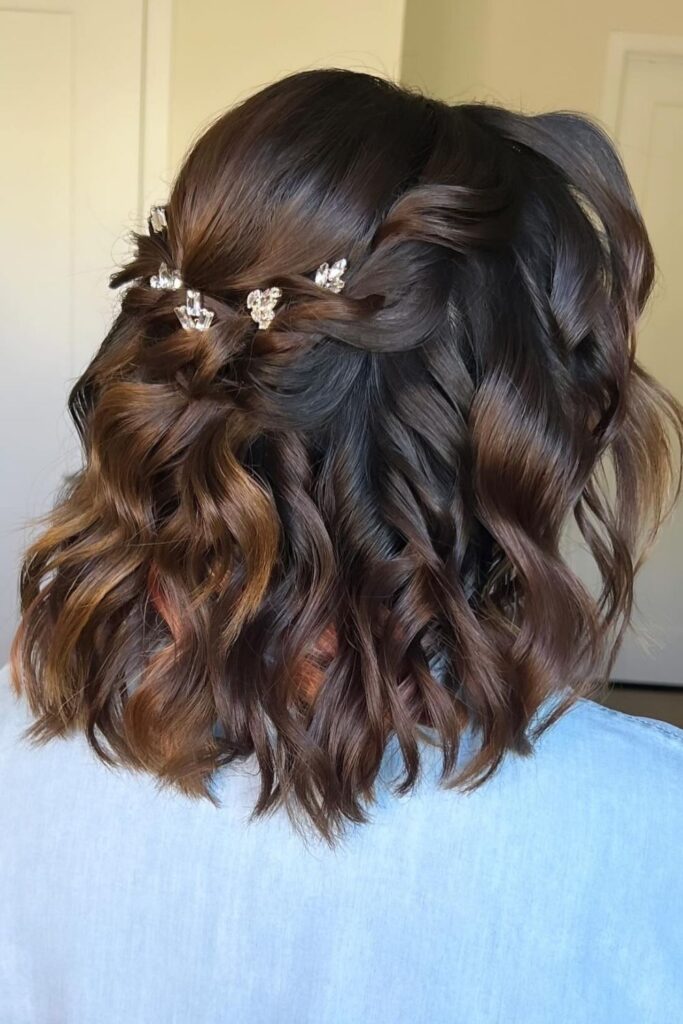 Dark wavy bob with a twisted half-up section and crystal hair pins