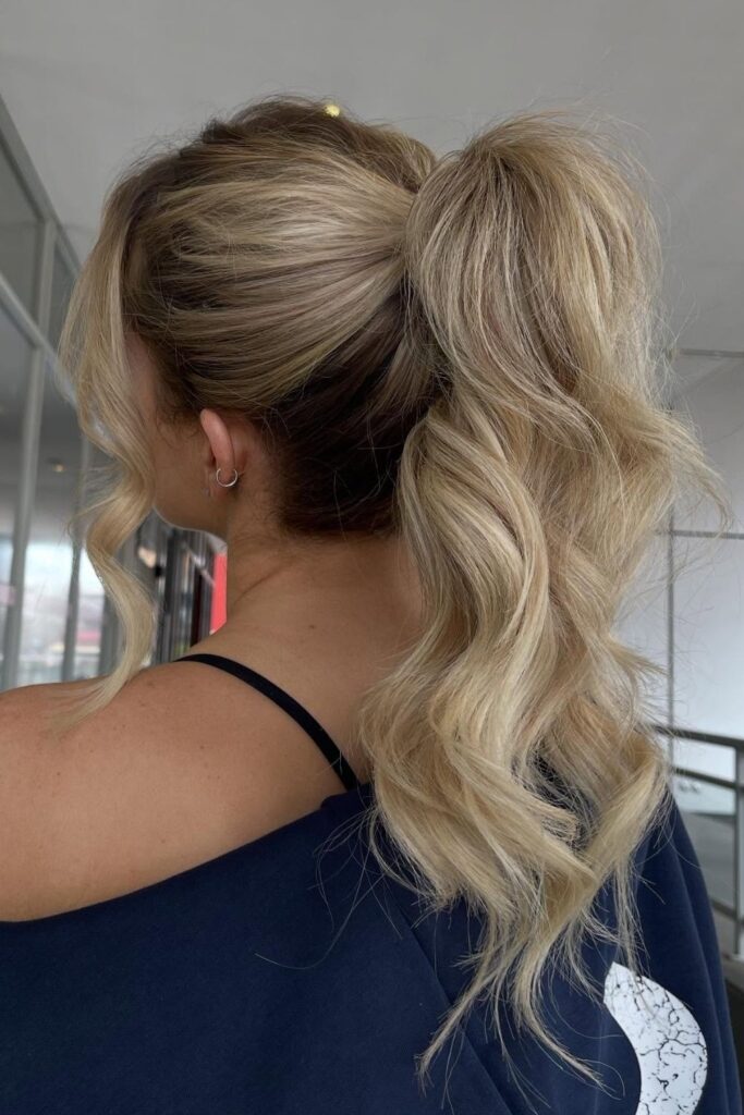 Voluminous high wavy ponytail on blonde hair with teased crown