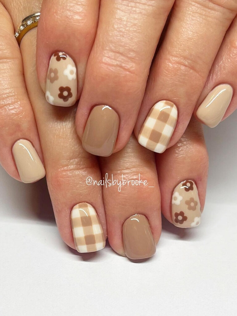 Short squoval nails in warm nude and beige with cream gingham check accents and brown and white retro daisies.