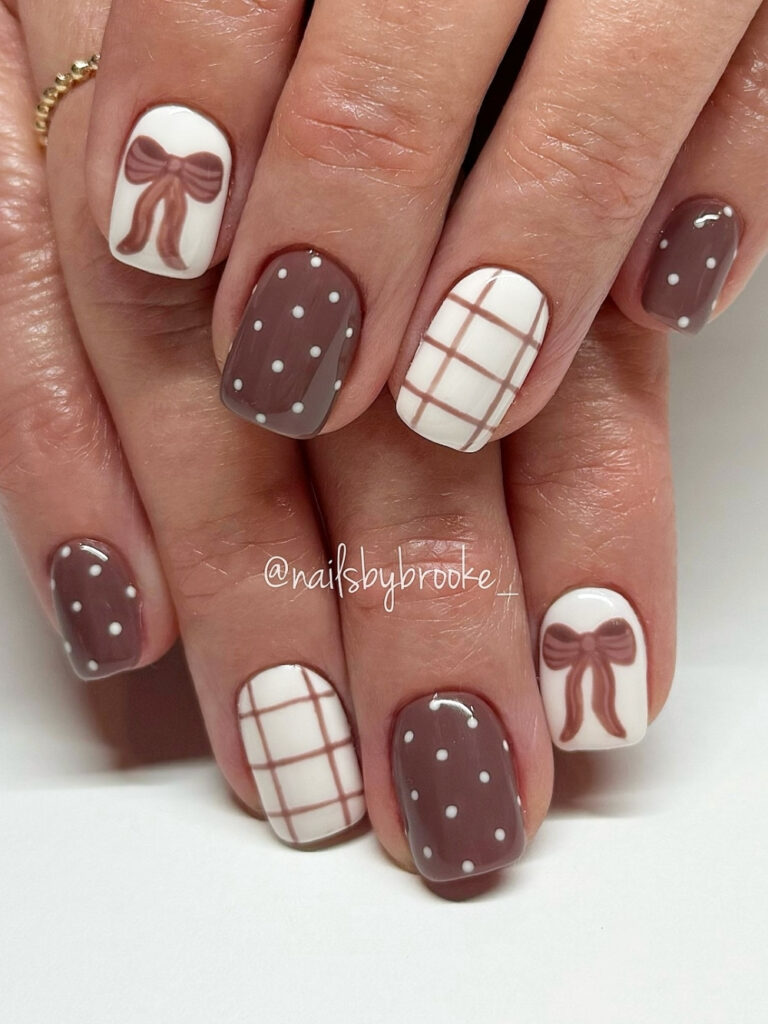 Short square nails in dusty mocha with white polka dots, cream nails with mauve plaid, and a hand painted bow accent.
