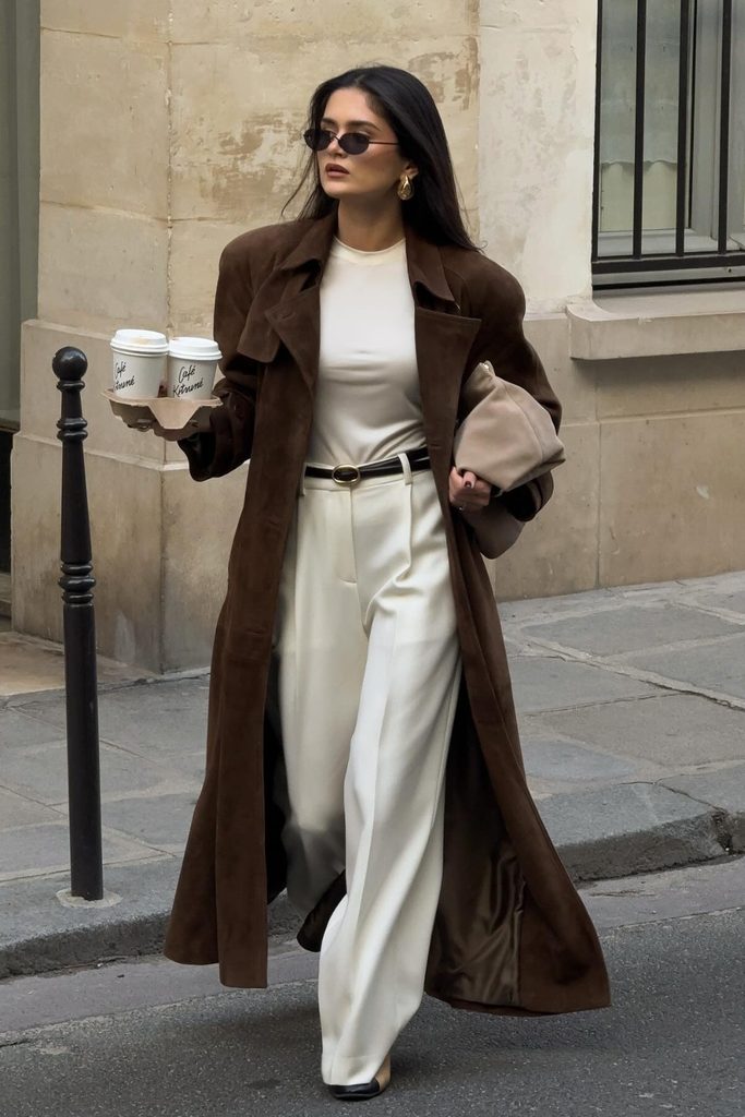 Long brown suede trench coat worn over a cream sweater and trousers