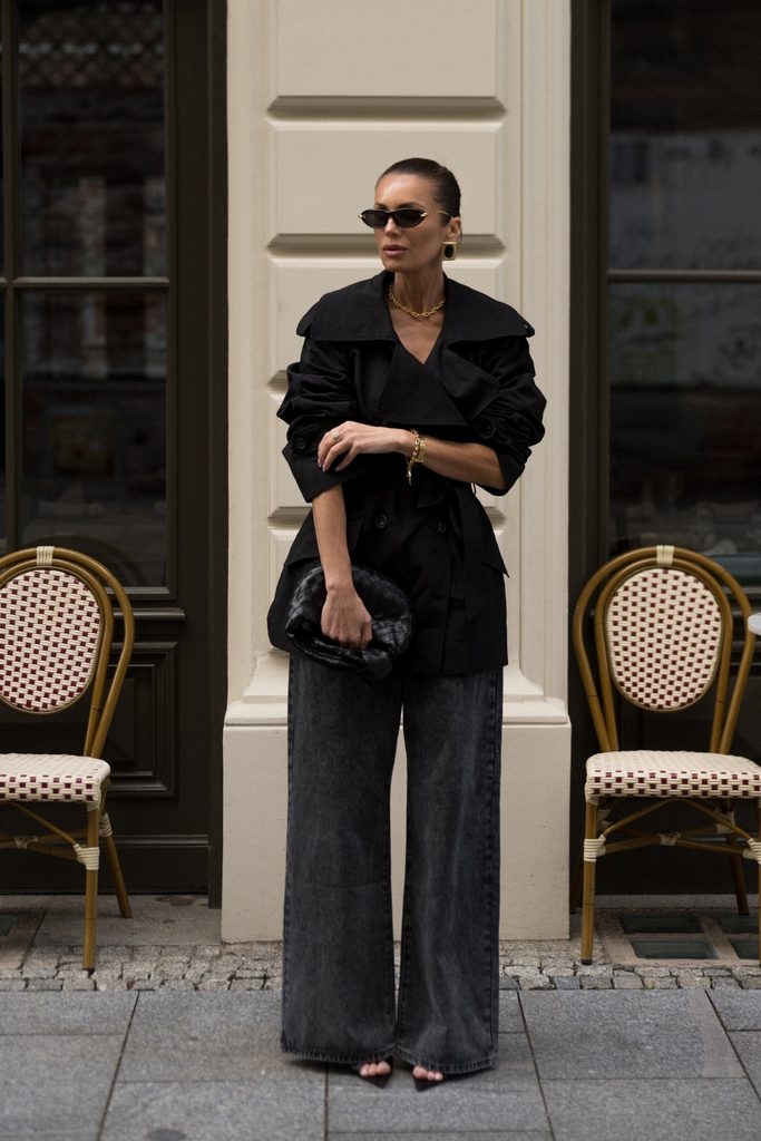 Black wrap trench coat with washed black wide-leg jeans