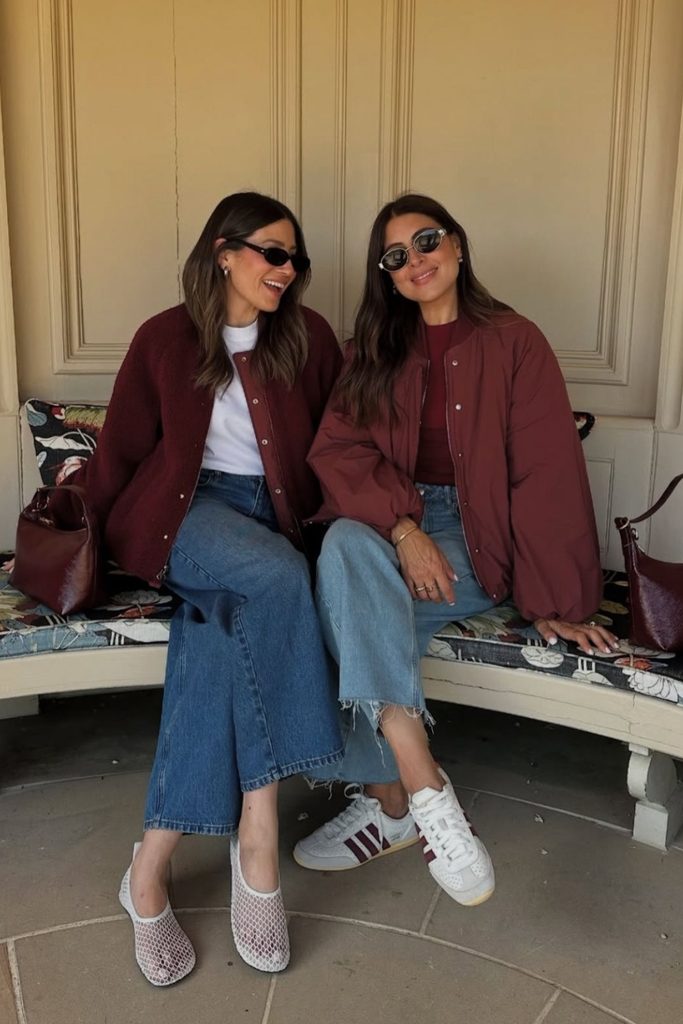 Matching burgundy bomber jackets with jeans and sneakers