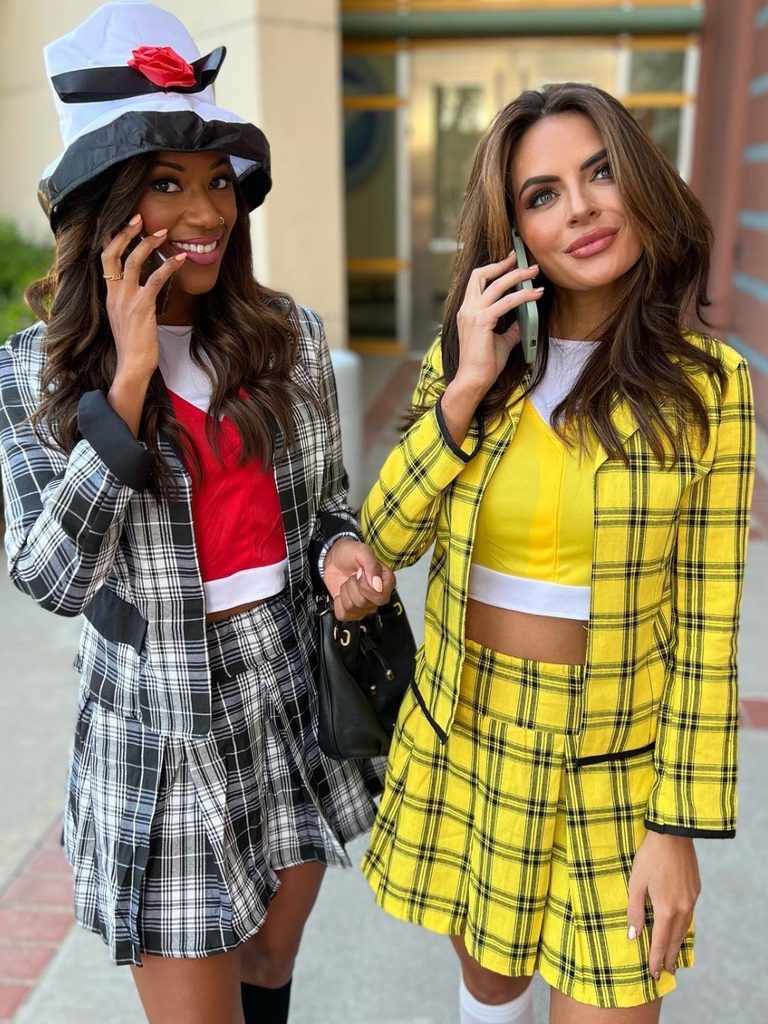 Two friends in matching plaid blazers and mini skirts inspired by Clueless.