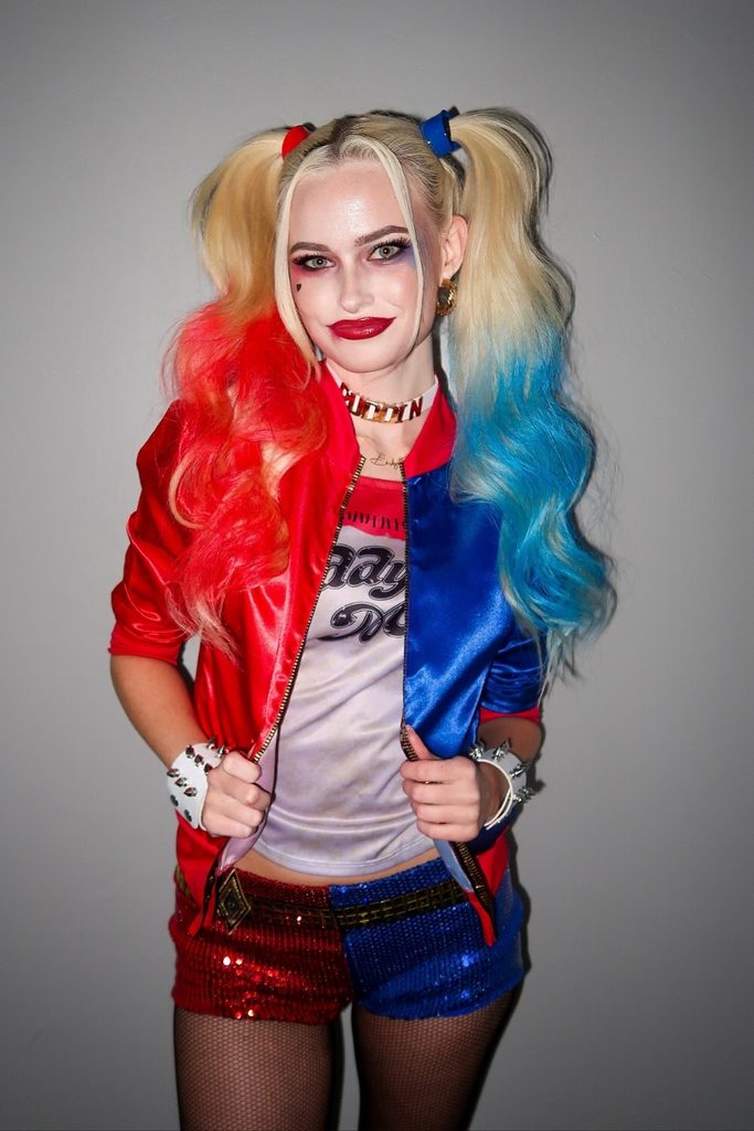 Woman with red and blue pigtails dressed as Harley Quinn.