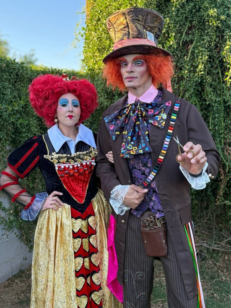 Couple dressed as the Queen of Hearts and Mad Hatter from Alice in Wonderland.