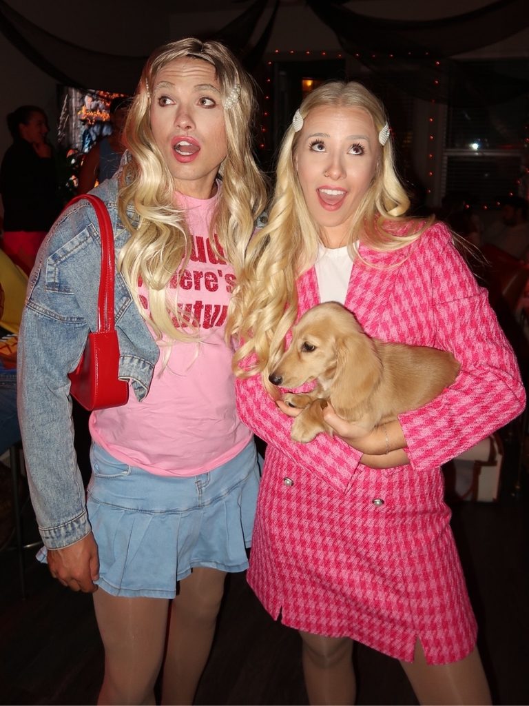 Two friends dressed as characters from White Chicks, wearing blonde wigs and houndstooth outfits.