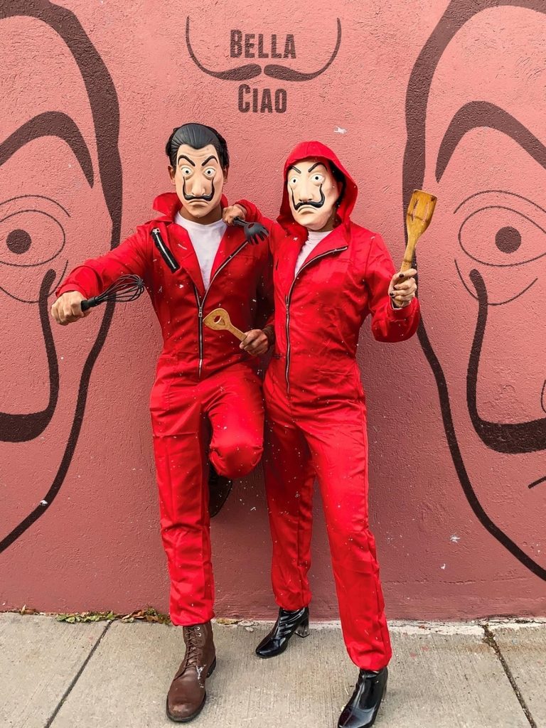 Duo wearing red jumpsuits and Dalí masks inspired by Money Heist.