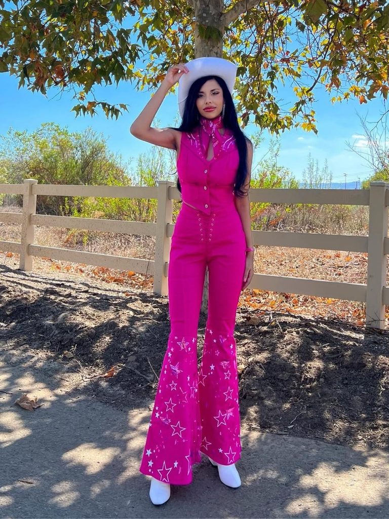 Woman wearing a pink star-print jumpsuit and white cowboy hat inspired by Western Barbie.
