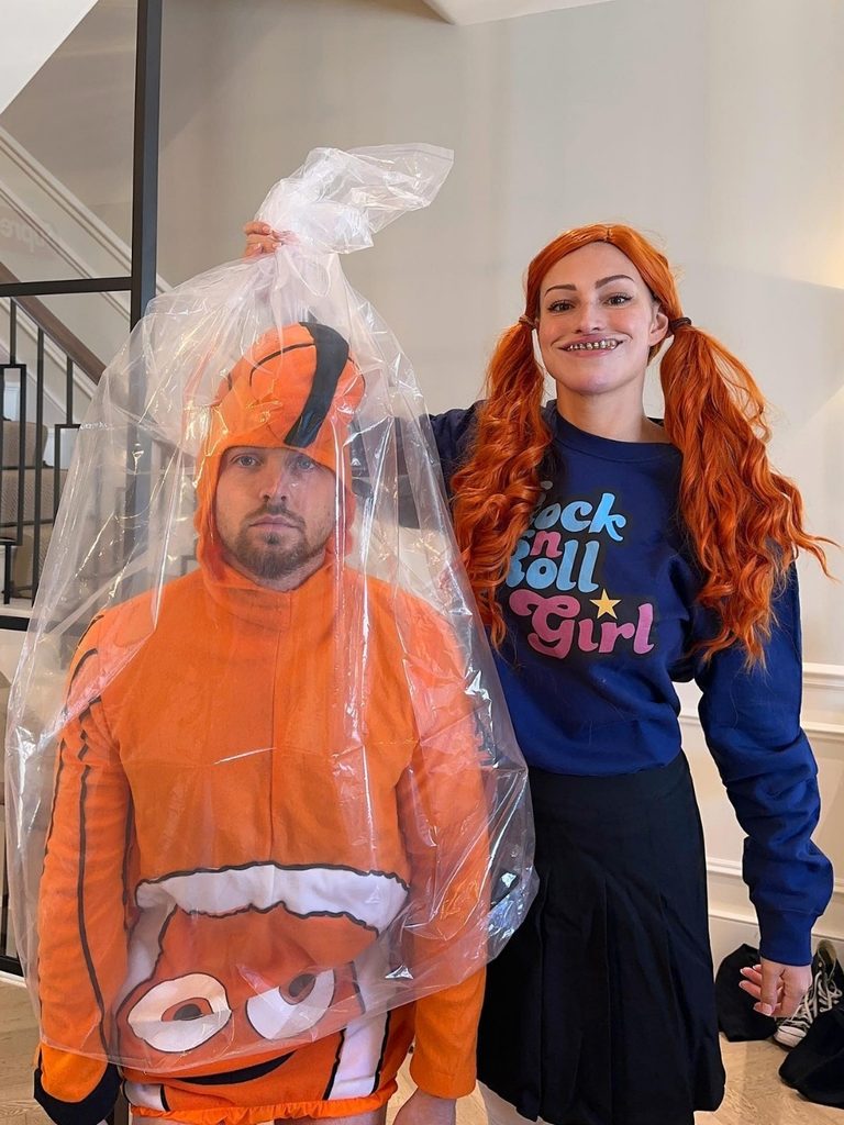Person dressed as Nemo from Finding Nemo inside a clear plastic bag, while a woman dressed as Darla holds the bag.