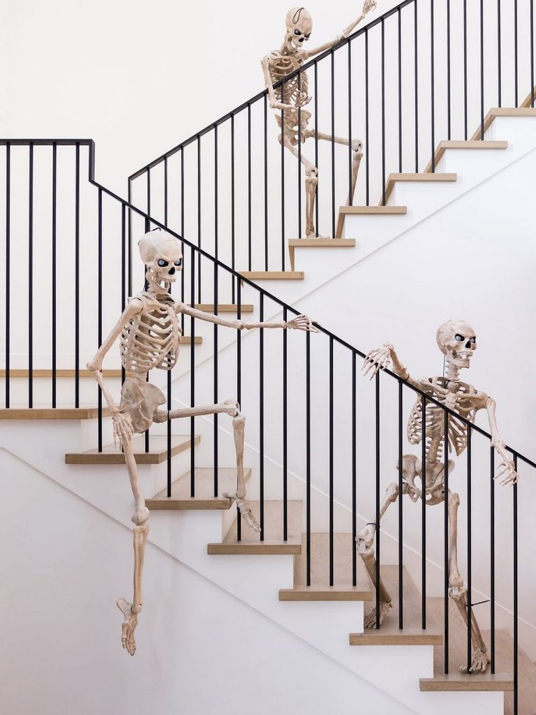 Modern staircase with life-size skeletons climbing the steps