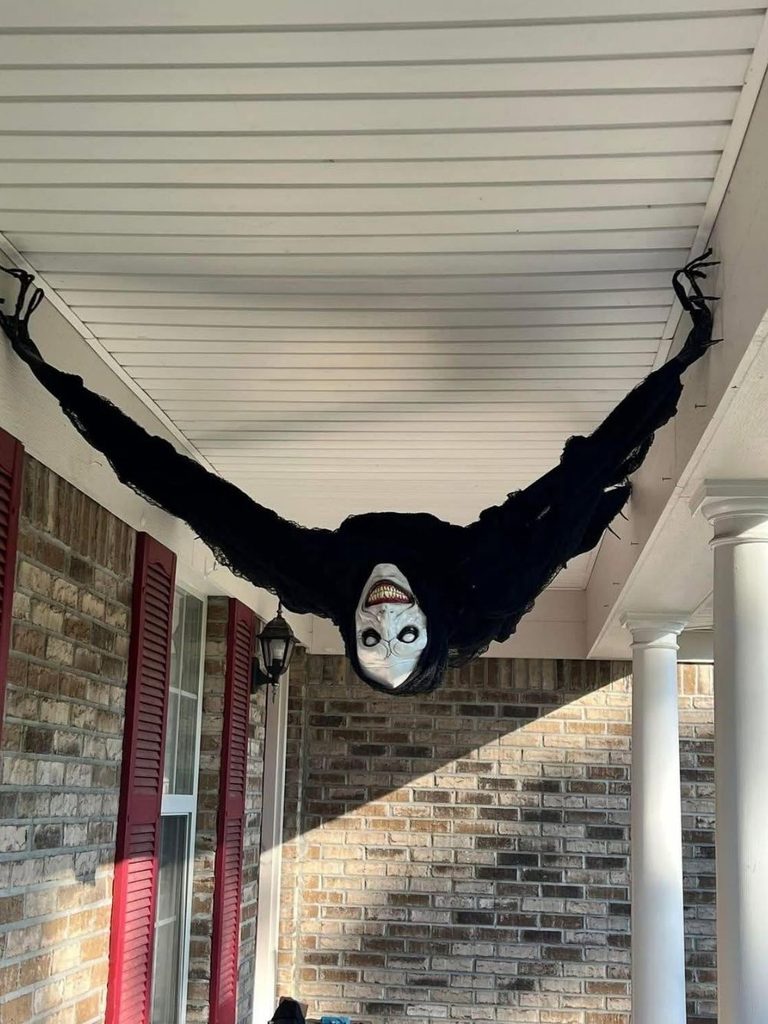 Giant creature prop stretched across a porch ceiling