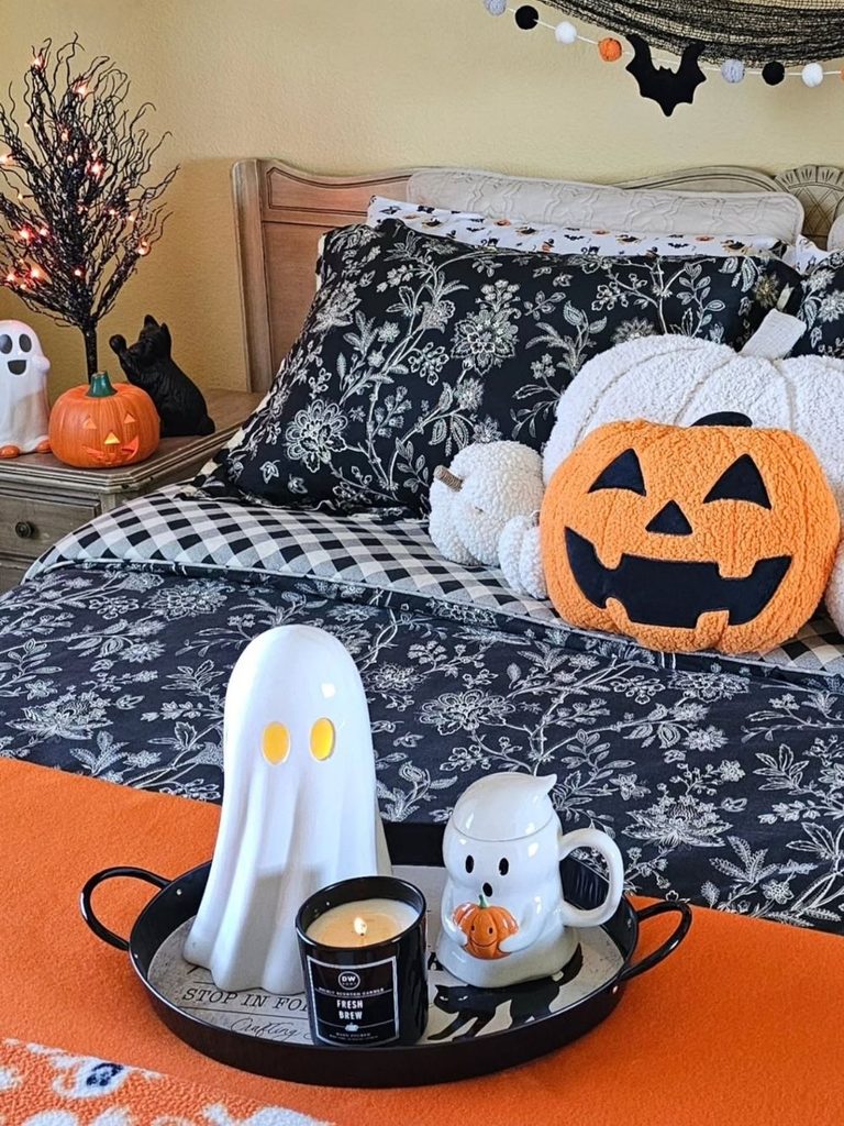 Black-and-white bedroom with pumpkin pillows and a small Halloween garland