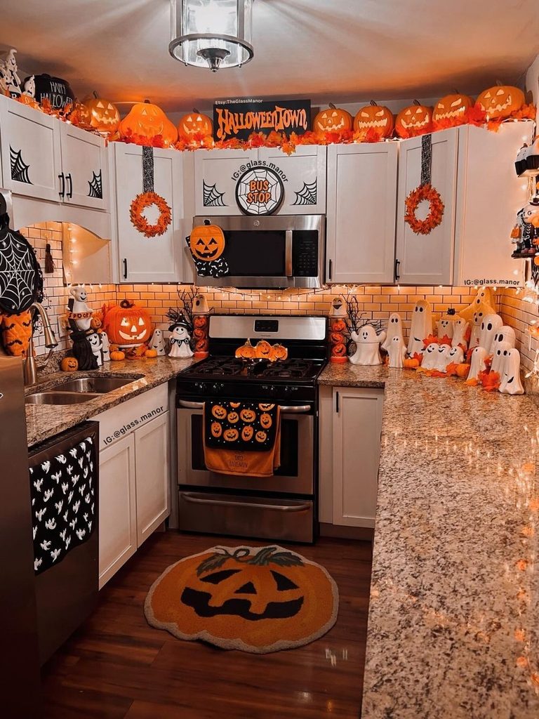 Kitchen filled with cute Halloween decor such as jack-o’-lanterns along the cabinets and ghosts on the counter