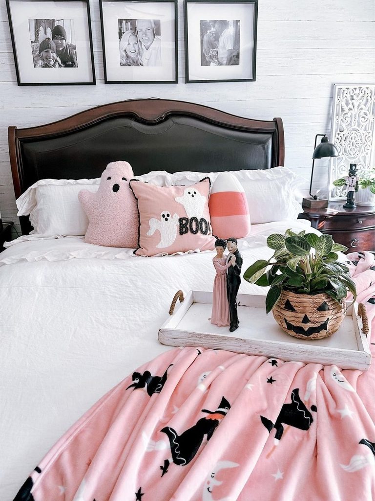 Bedroom with soft pink ghost pillows and a pumpkin basket