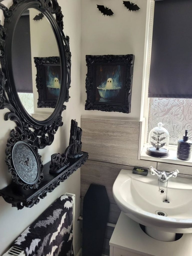 Bathroom with eerie bathtub artwork in dark frames