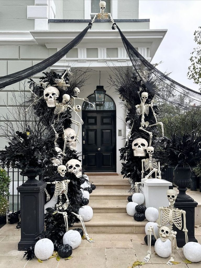 Townhouse entrance covered with black cheesecloth and climbing skeletons