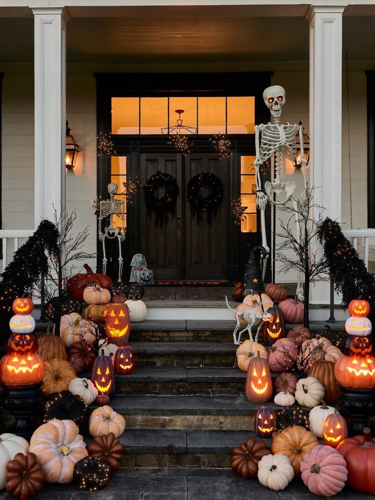 Front porch steps covered with orange, pink, and black pumpkins