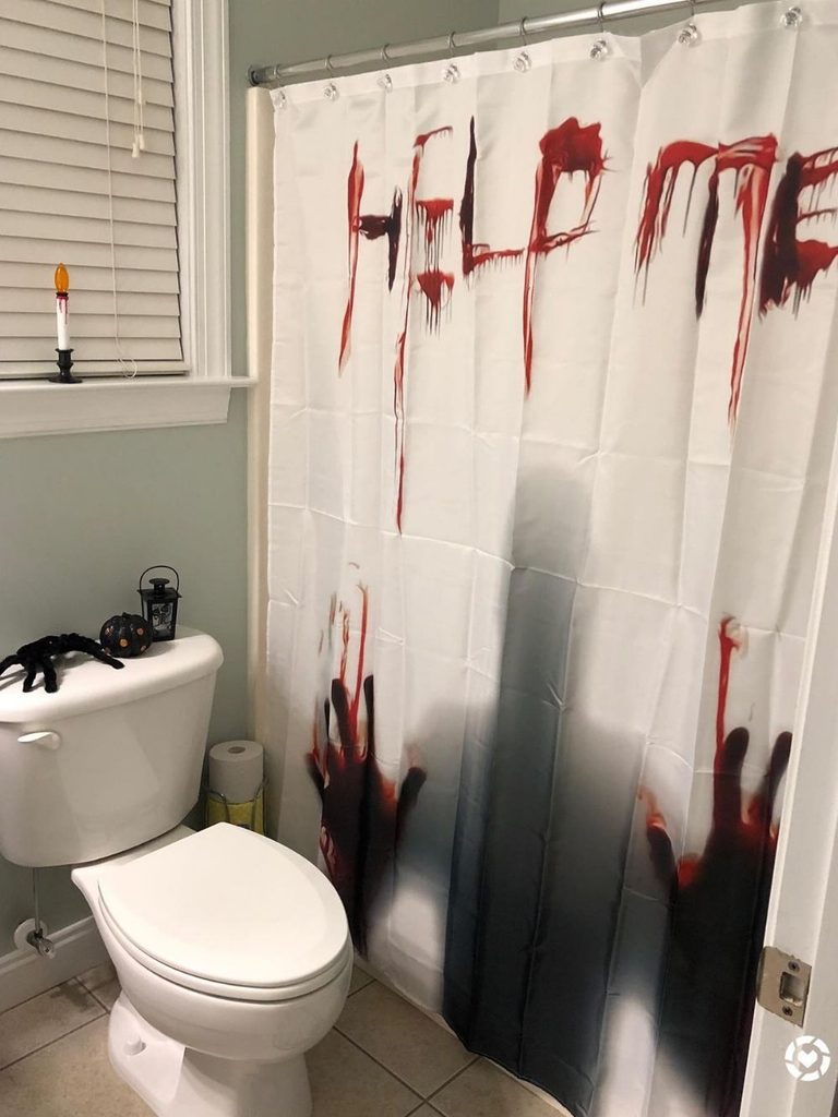 Scary Halloween decorations on a bathroom featuring a bloodied “help me” shower curtain