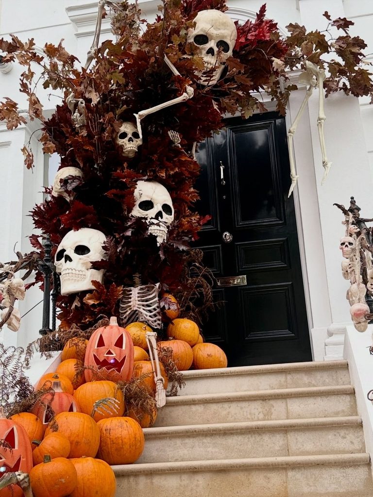 Halloween front door decorated with skulls and fall foliage