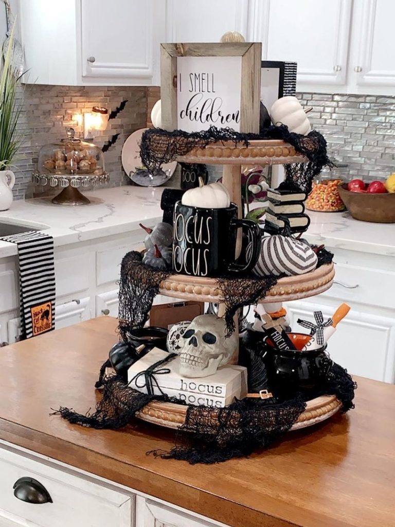 Kitchen island with a Halloween-themed tiered tray, skull, and cheesecloth