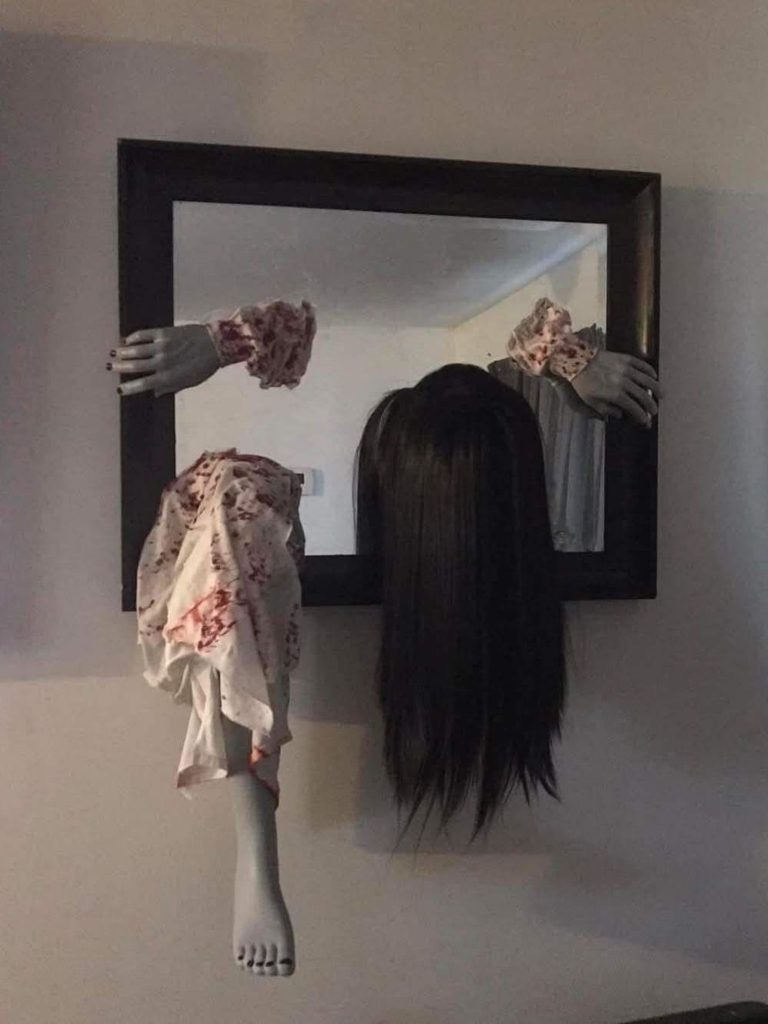 DIY ghostly hands and dark hair crawling through a mirror