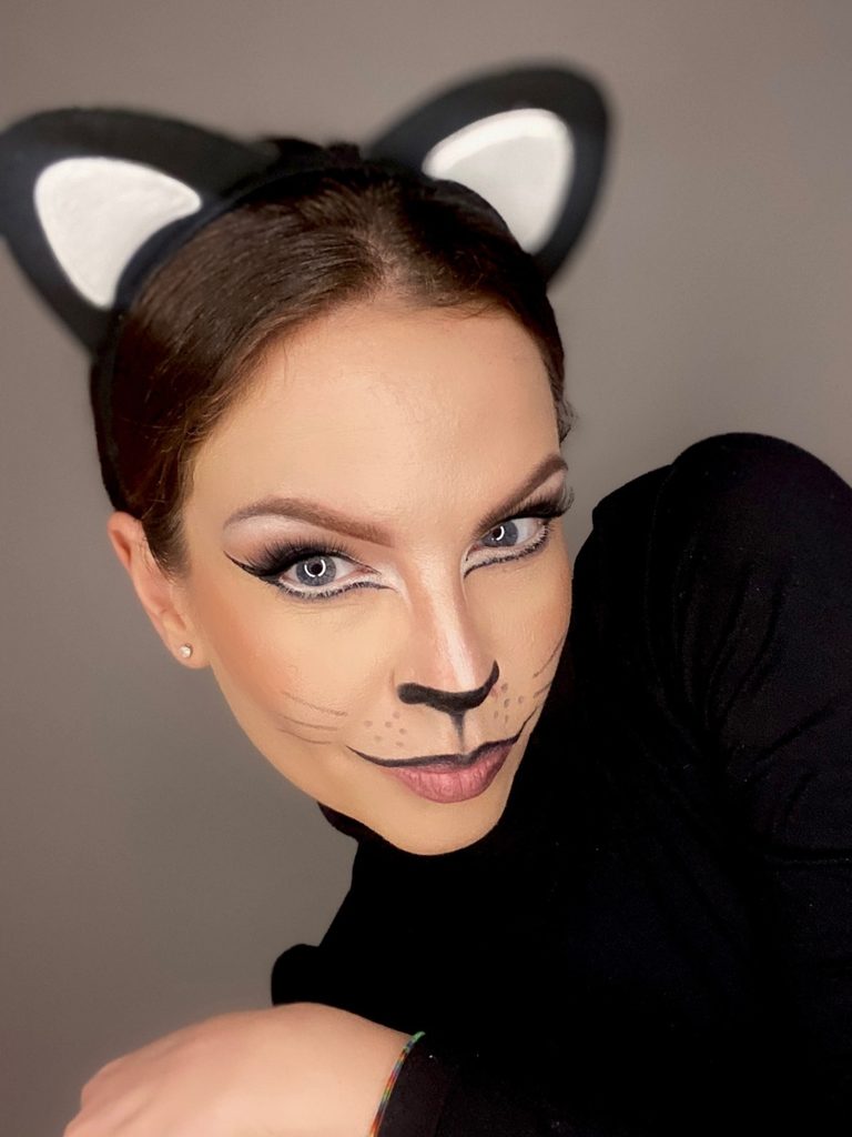 A painted black nose, delicate whiskers, and a soft smoky eye create this simple Halloween makeup idea for a black cat costume.