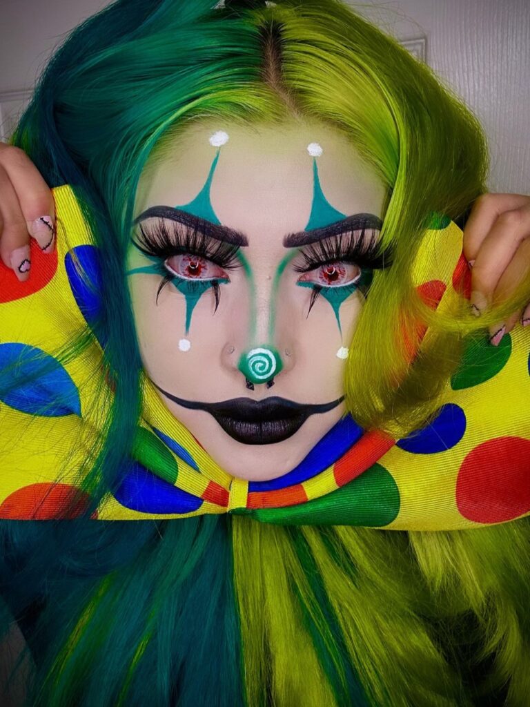 Colorful clown makeup with teal diamond-shaped eye designs, a spiral nose, and neon green and blue hair.