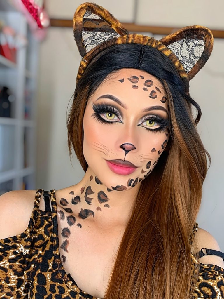 Small black spots scattered across the cheeks, neck, and chest complete this cheetah-inspired animal makeup look.