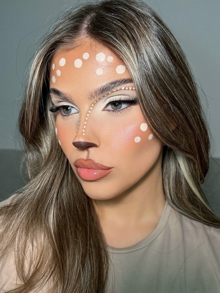 Soft white dot markings across the forehead and cheeks, paired with doe-eyed makeup, create a cute fawn look.