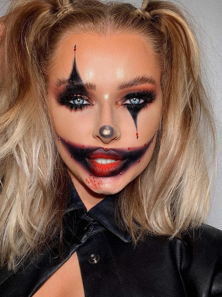 Harlequin-inspired Halloween makeup, but more creepy, with sharp black diamond shapes around the eyes and an exaggerated red and black mouth.