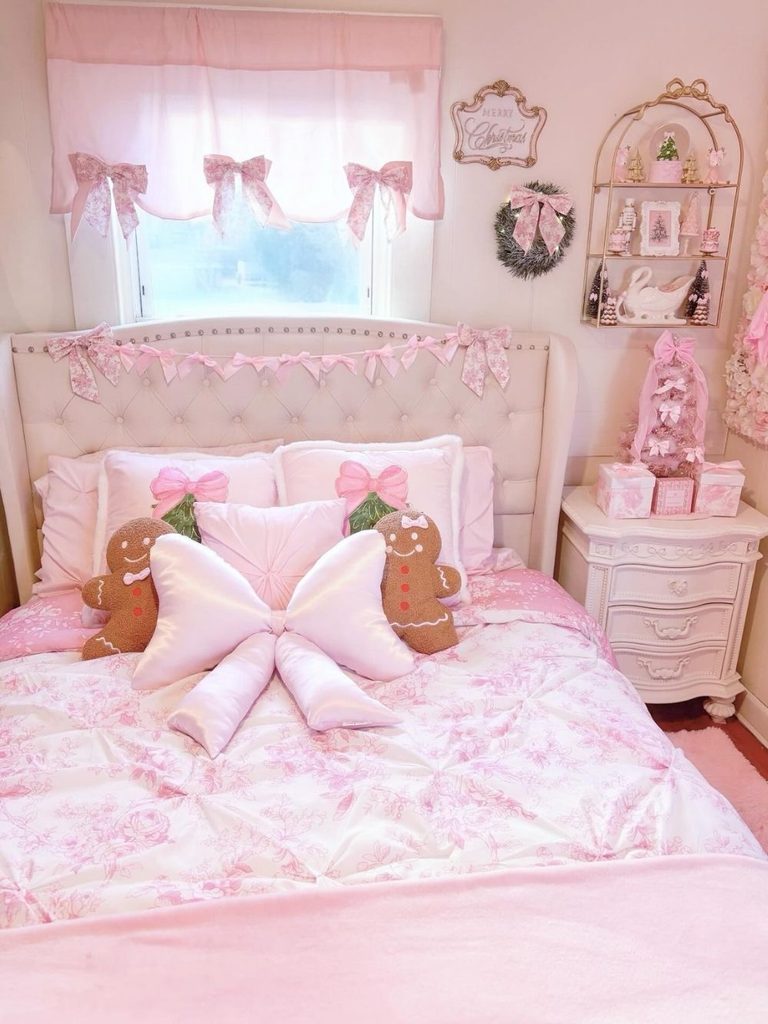 Pink Christmas room decor with toile bedding, a bow pillow, gingerbread cushions, and blush mini trees