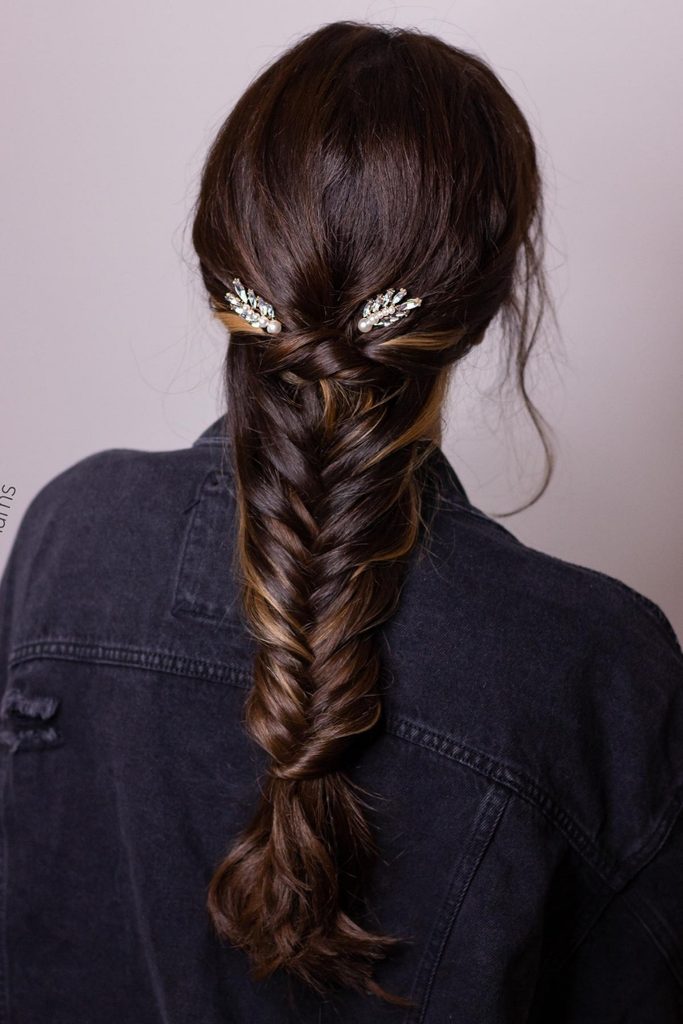 Loose fishtail braid with crystal hair pins and a denim jacket