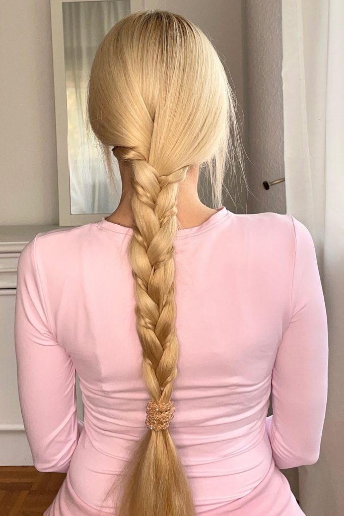 Long blonde braid with a smaller braid woven into one strand and a crystal hair tie at the end