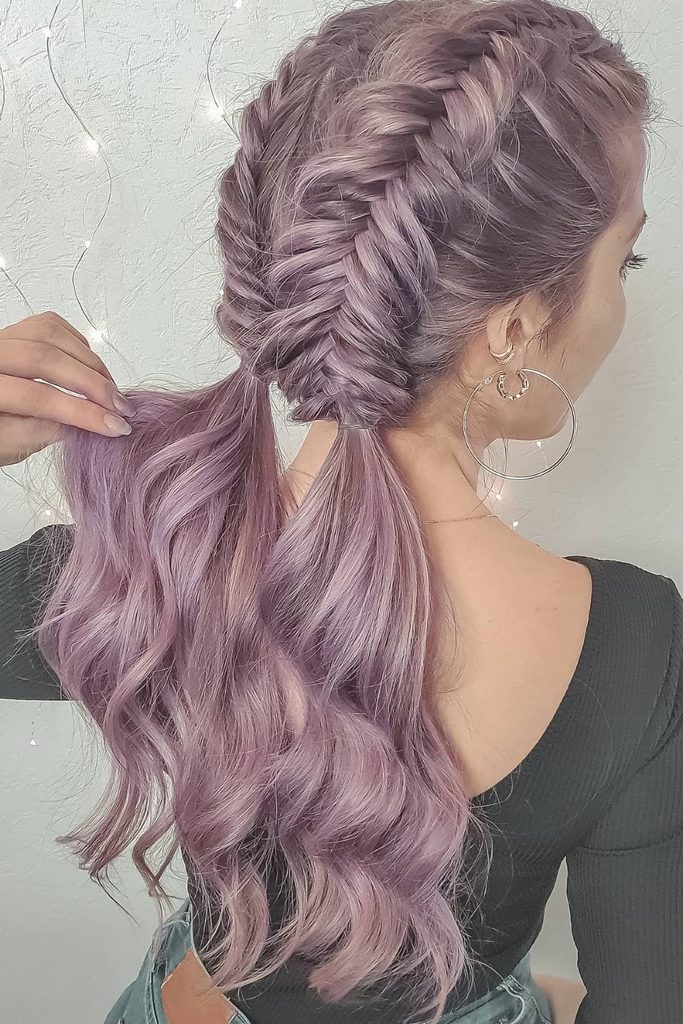Double fishtail braids meeting in a low, wavy ponytail in pastel lavender hair