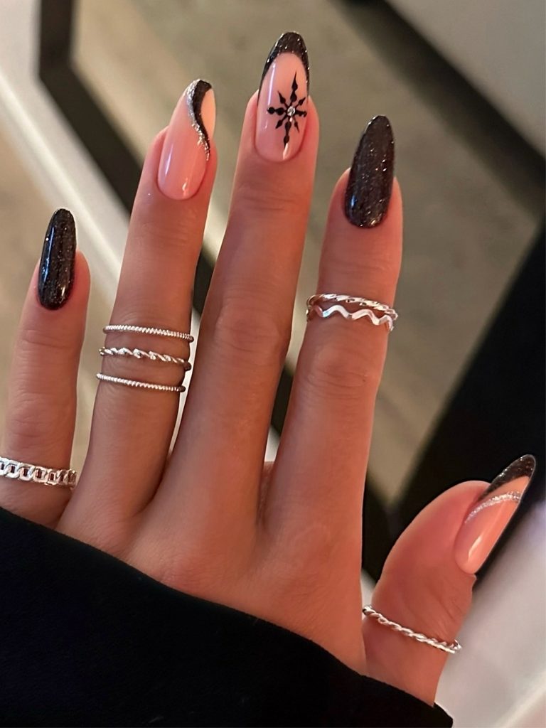 Black snowflake nails with peach swirl French tips